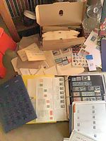 Lot overview showing binders, catalogs, loose pages, box of glassine envelopes and first day covers