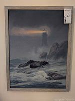 Full view of framed lighthouse seascape painting