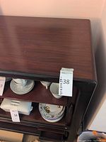 Top and upper shelf of veneer sideboard with tag showing lot number