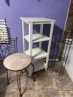Overall view of all three items: white shelf, bronze stool, black wire rack