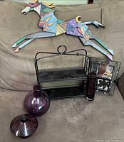 Group shot of wall art horse, metal shelf, three purple glass pieces and mirror