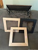 Overall lot view showing three frames and wrought iron shelf