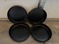 Top view of four black speckled dinner plates