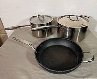 Overall view of frying pan and two covered pots