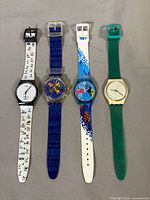 Front view of all four Swatch watches side by side