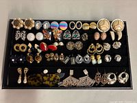 Full tray view showing over 30 pairs of earrings