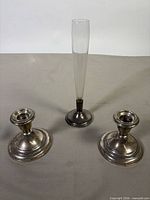 Pair of weighted sterling candleholders and glass bud vase overview