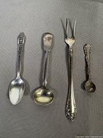 All four sterling silver utensils laid out side by side