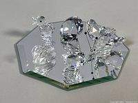 Group of crystal pieces on mirrored base showing duckling, swan and butterfly top