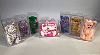 Seven Beanie Babies in individual acrylic boxes