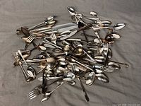 Pile of assorted silver-tone spoons, forks, knives and serving pieces