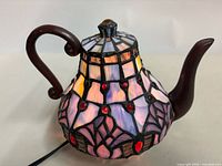 Front view of stained glass teapot lamp showing color and design
