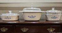 Three casseroles with lids displayed side by side