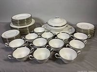 Entire dinner service displayed including stacks of plates, soup bowls, covered vegetable bowl on platter