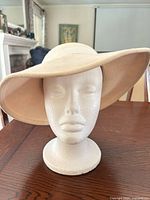 Front view of beige floppy hat on stand