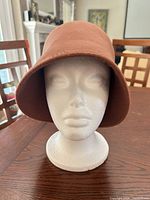 Front view of brown wool felt cloche hat on mannequin head