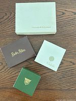 Four vintage department-store jewelry boxes on table