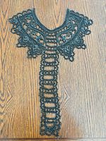 Full view of black beaded applique collar laid flat