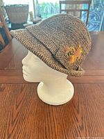 Left side view showing cloche shape and feather accent