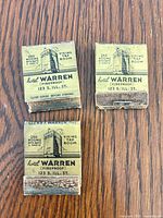 Fronts of three Hotel Warren matchbooks showing text and graphics