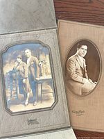 Open folio showing both mounted photographs and studio imprints
