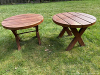 both round wooden tables side by side on grass
