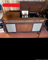 Stereo console with lid open showing turntable and manual