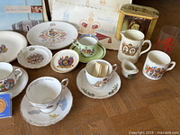Group view showing cups, saucers, plates, tin, medal, magazines