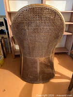 Back view showing tall oval cane back and lower cane panel