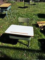 Front view of green metal student desk with speckled laminate top and matching chair