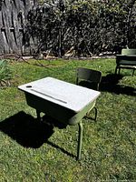 Desk and chair outdoors showing laminate top, inkwell hole, and green metal frames