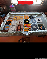 Overview of all records laid out on table showing sleeves and unsleeved discs