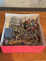 Box containing variety of costume jewelry