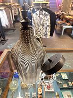 Front angled view of chevron glass pendant lamp showing shade, cap, cord and canopy