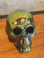 Front view of iridescent skull figurine showing facial features and reflective finish
