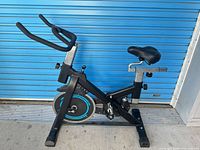Full side view of Altrax Fitness exercise bike showing frame, seat, handlebars, flywheel