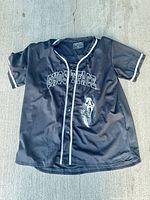 Front of black Ghost Face baseball-style shirt showing white piping, Ghostface text and mask graphic