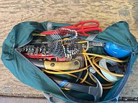 Top view of open green tool bag showing assorted tools
