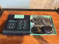 Open box with muscle stimulator pads and control unit visible