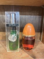 Two fragrance bottles side by side: Brut spray in box and Obsession bottle