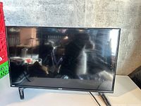 Front view of RCA 32" LED TV on stand