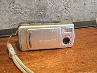 Front view showing lens, flash, wrist strap