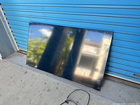 Front view of 55-inch TCL television leaning against wall