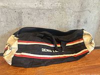 Full view of duffel bag showing stripes and printed name