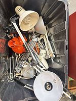 Bin containing multiple adjustable desk and task lamps, cords visible
