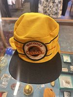 Front view of yellow hat showing embroidered Vancouver Canucks logo and black brim