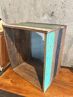 Angled view of rectangular crate showing interior and wood grain