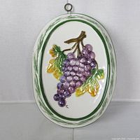 Front view showing raised grape design and hanging ring