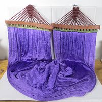 Hammock folded showing mesh fabric, spreader bars, suspension cords and rings
