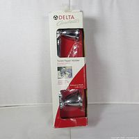 Front of boxed Delta toilet paper holder